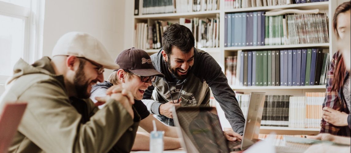 three men motivated at work laughing, how to self-motivate